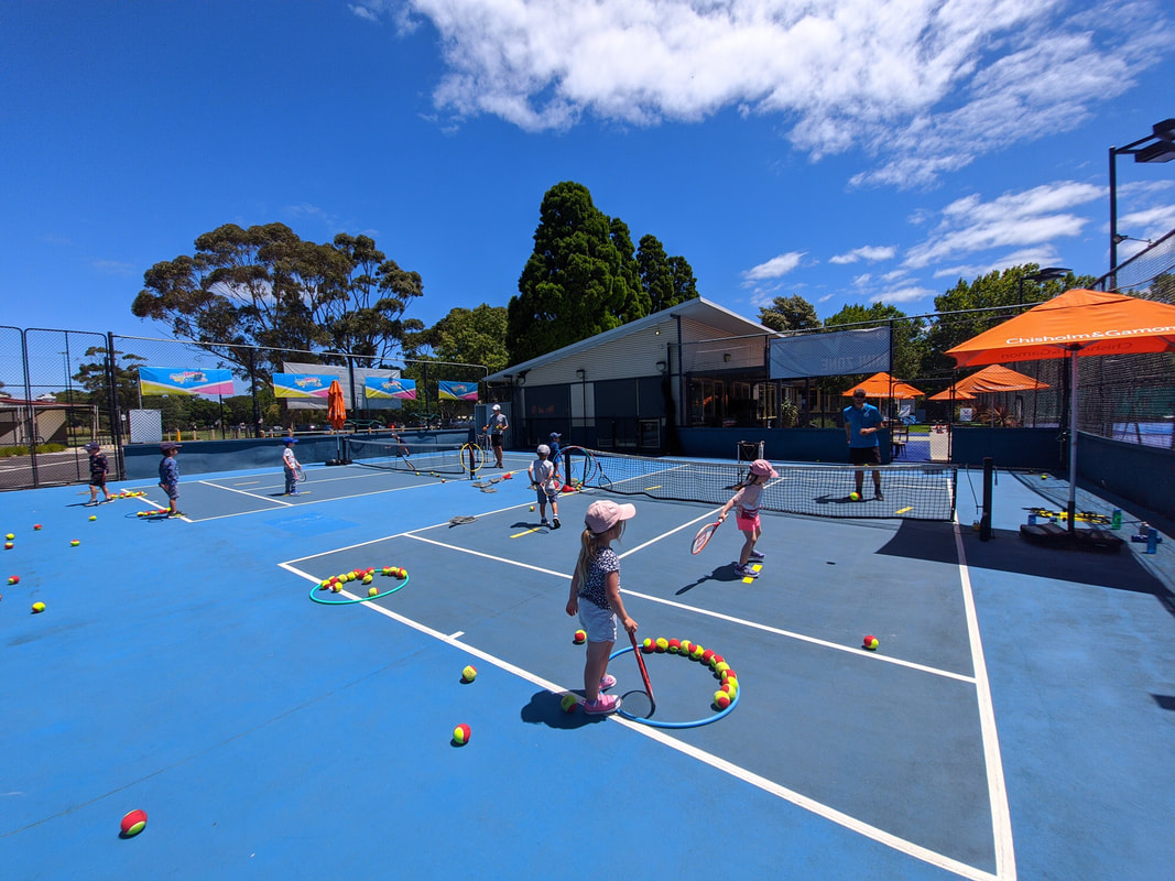 Junior tennis players learning on court at Elsternwick Park